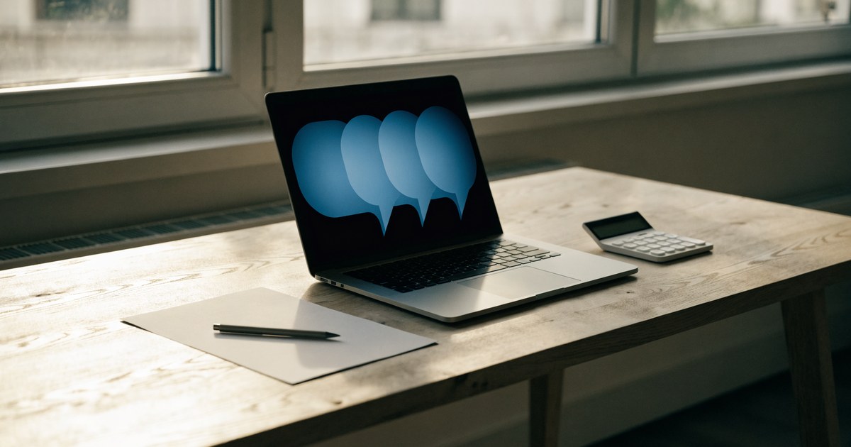 A tidy desk with a laptop showing soft glowing chat bubbles, a blank sheet of paper, a pen and a calculator.